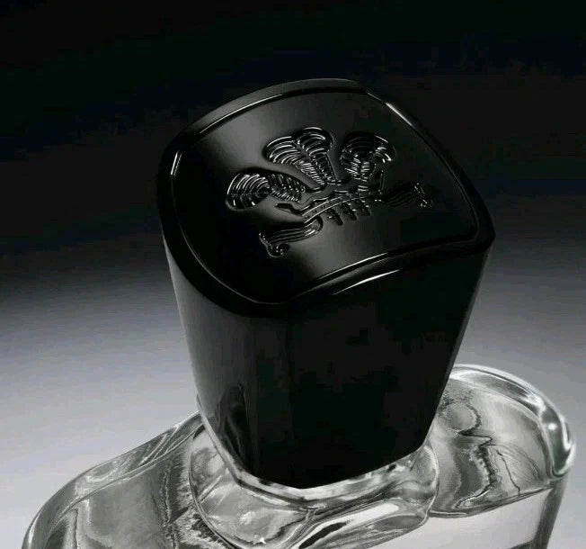 Black cylindrical container with a logo on top, placed on a clear base against a dark background