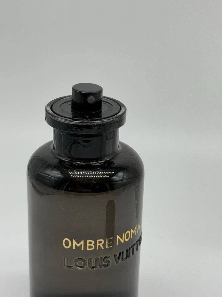 Black perfume bottle with 'Louis Vuitton' branding on a gray background