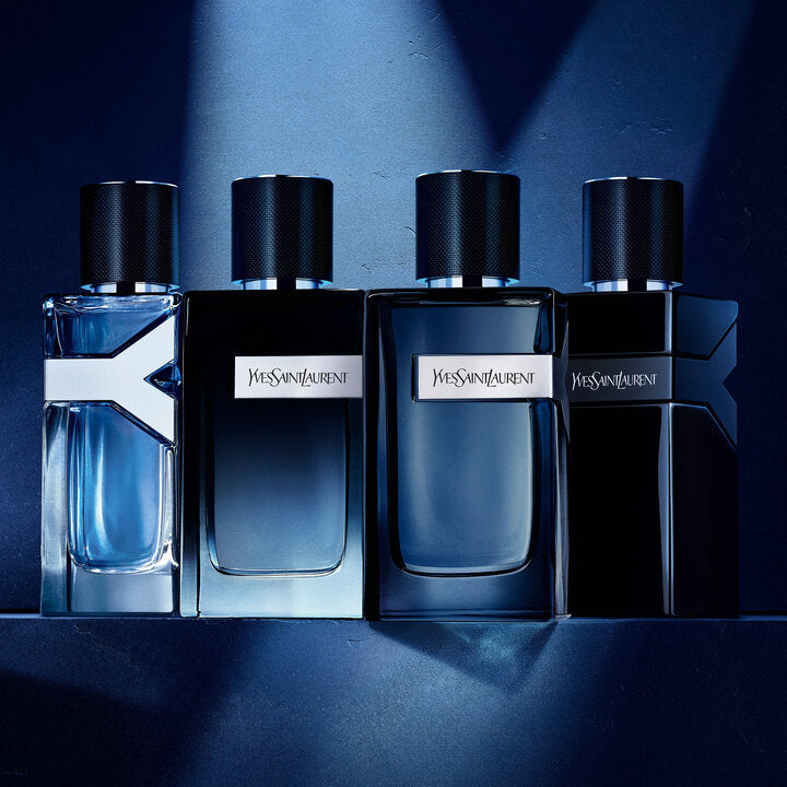 Four Yves Saint Laurent perfume bottles on a dark blue background