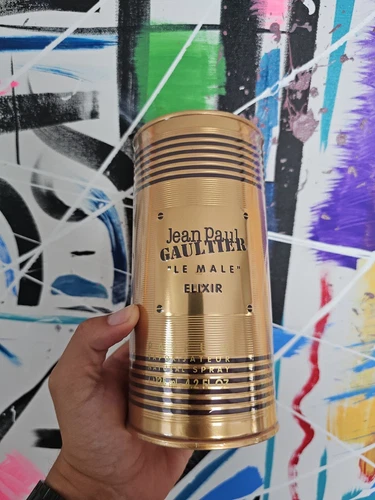 Gold cylindrical container with 'Jean Paul Gaultier Le Male Elixir' 