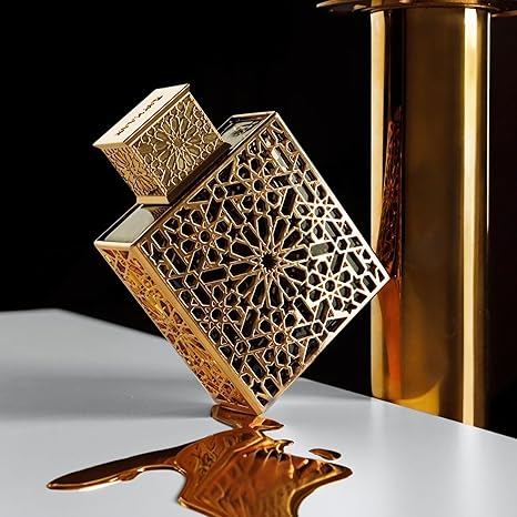 Gold perfume bottle with intricate design on a reflective surface