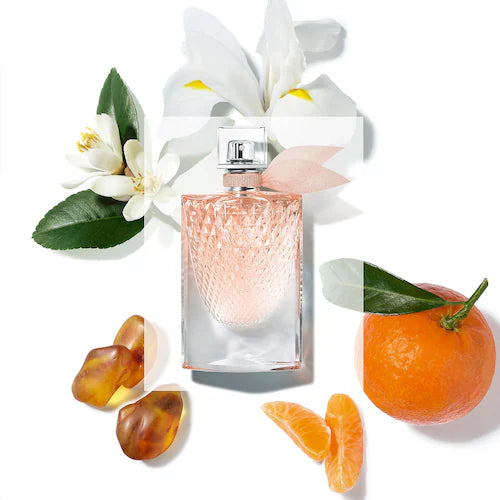 Perfume bottle with flowers and fruits on a white background