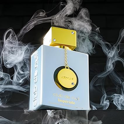 Perfume bottle with gold cap and chain, surrounded by smoke on a dark background