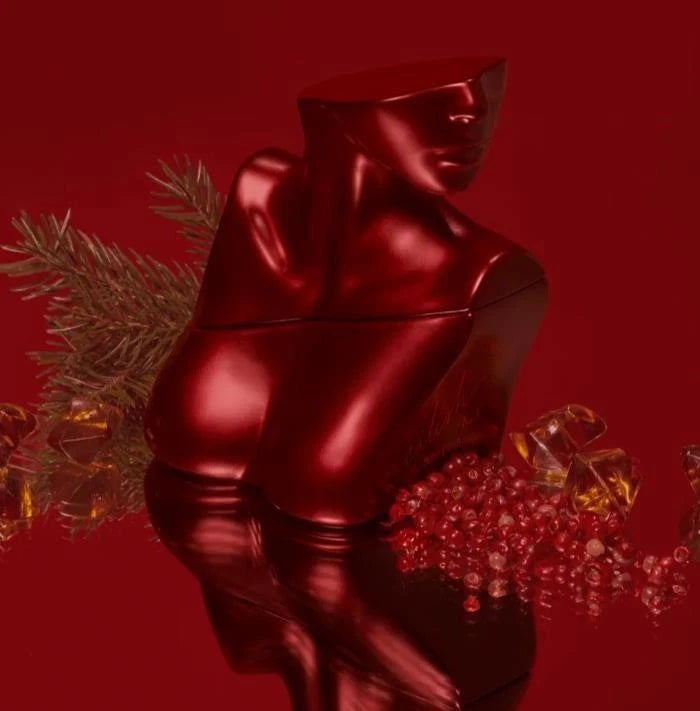 Shiny red statue on a reflective surface with decorative elements on a red background