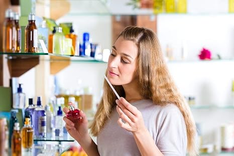 Woman smelling a perfume bottle in a store setting